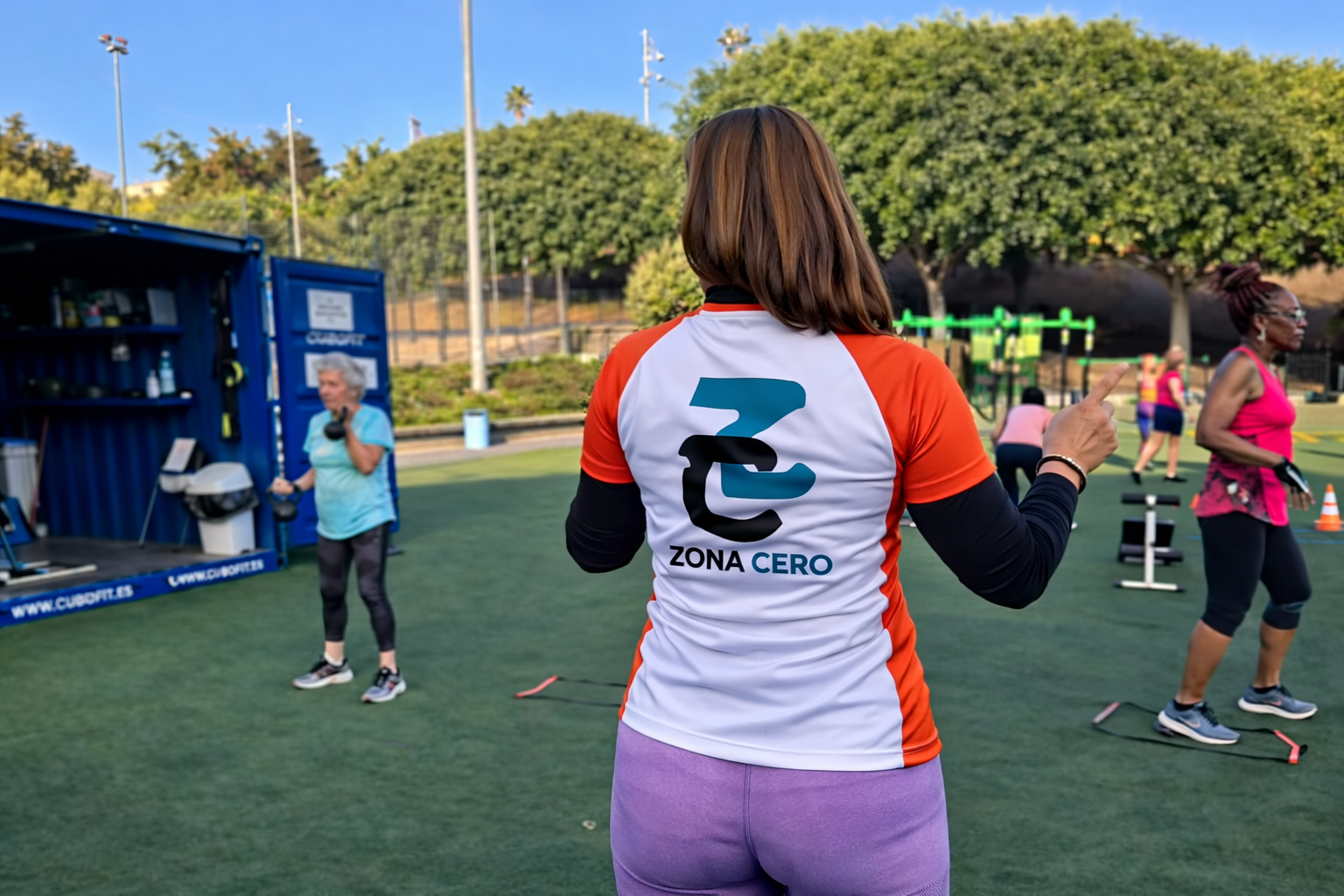 Actividad física en espacio abierto con una participante luciendo la marca de Zona Cero